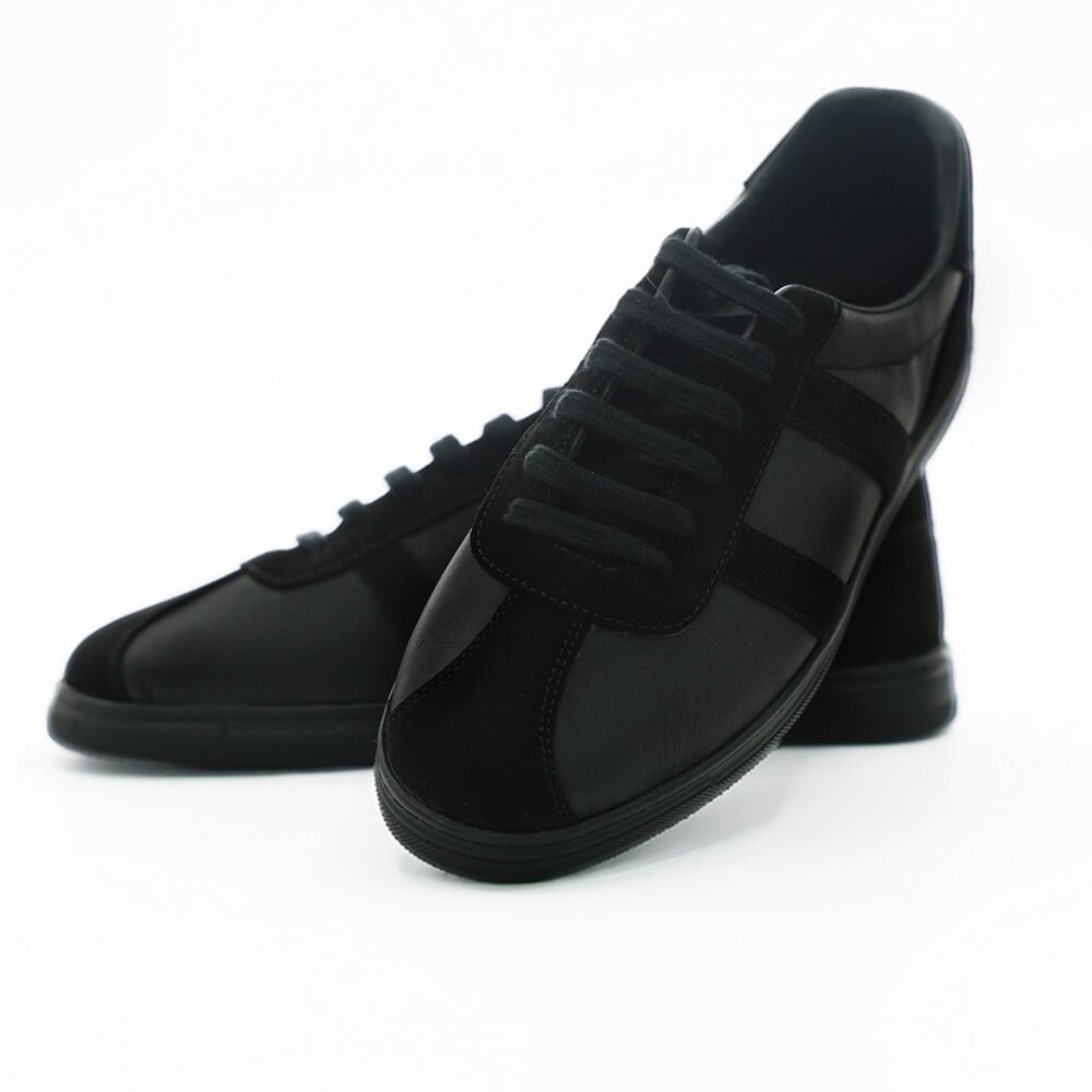 Siyah low-top erkek deri günlük sneaker çiftinin önden ve yandan sergilendiği fotoğraf