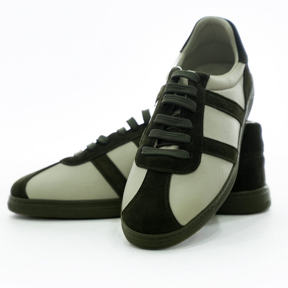 Krem deri yüzey ve haki süet detaylarla tasarlanmış low-top erkek sneaker çiftinin önden ve açılı şekilde konumlandırıldığı dinamik ürün fotoğrafı